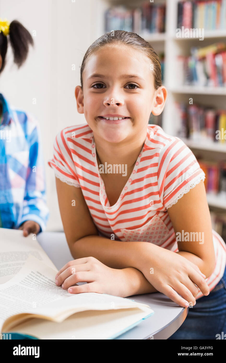 Schoolgirl reading a book in library Stock Photo - Alamy