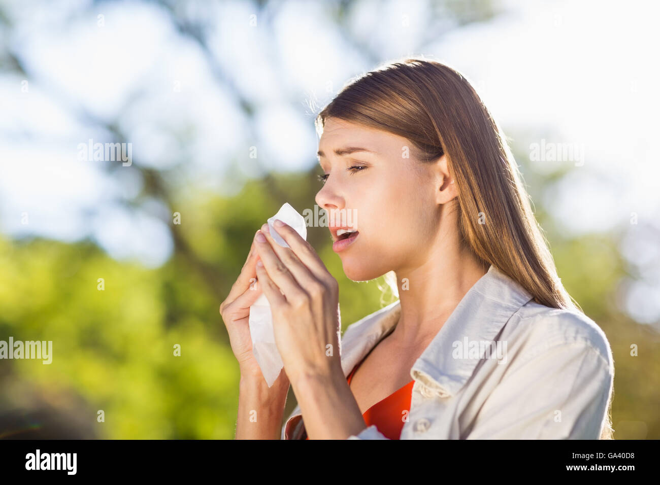 Beautiful woman using tissue while sneezing Stock Photo