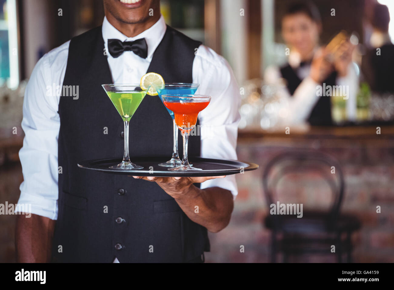 https://c8.alamy.com/comp/GA4159/bartender-holding-serving-tray-with-cocktail-glasses-GA4159.jpg