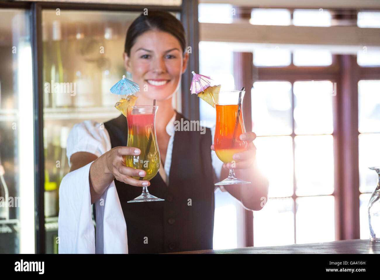 Waitress handing over cocktails Stock Photo Alamy