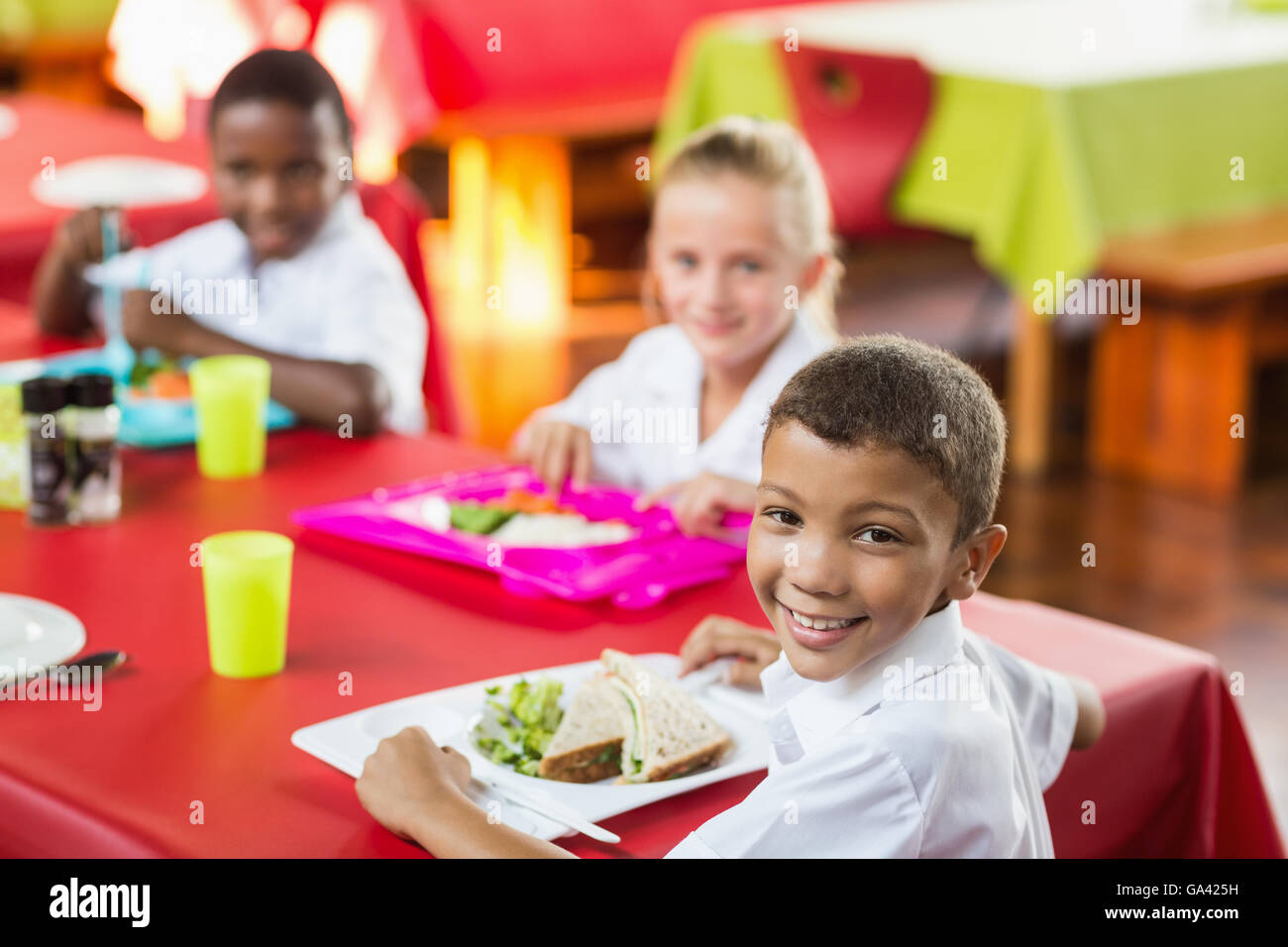Happy children having lunch together in primary school canteen Stock Photo  - Alamy