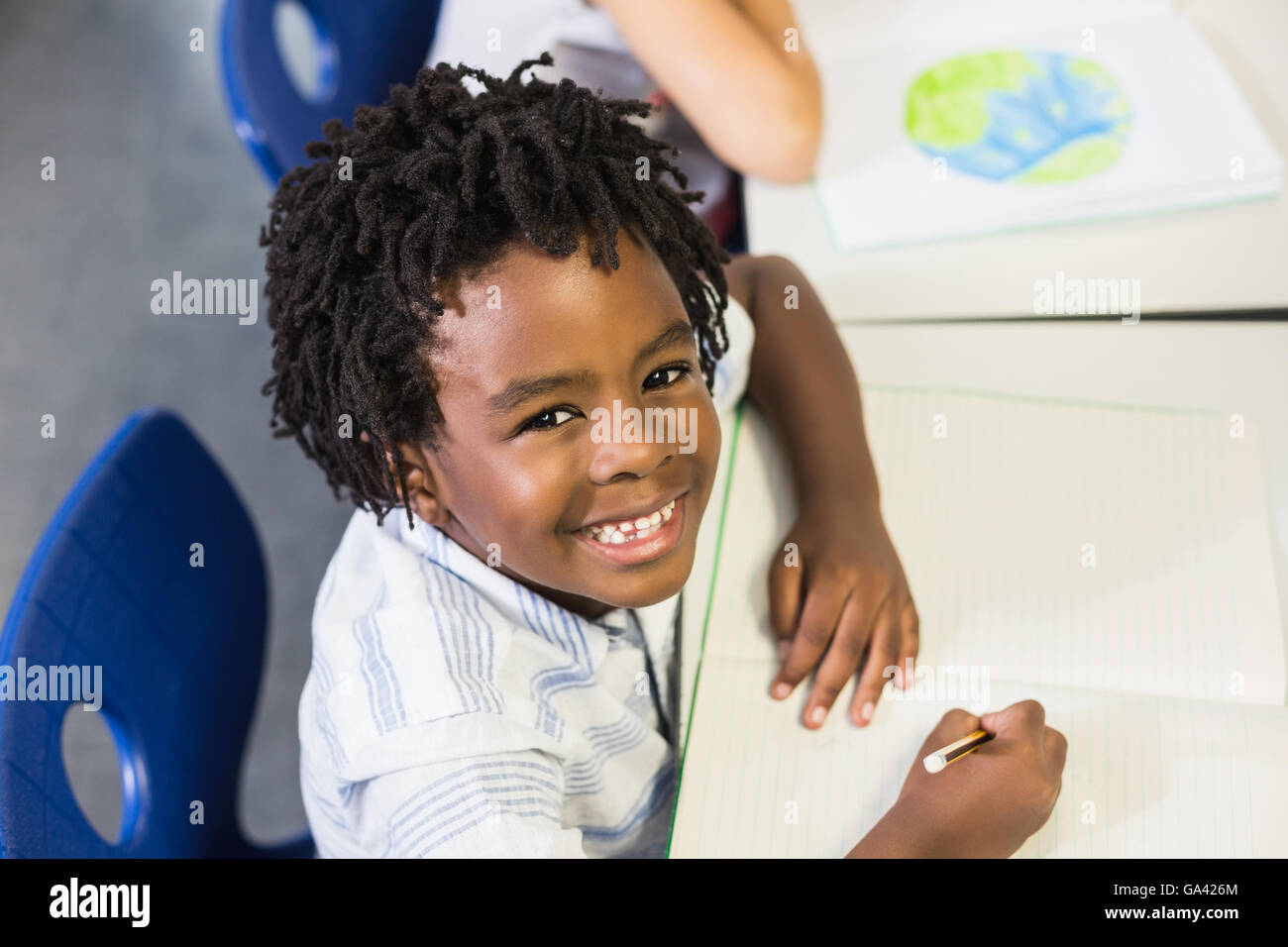 Portrait of schoolboy studying in classroom Stock Photo - Alamy