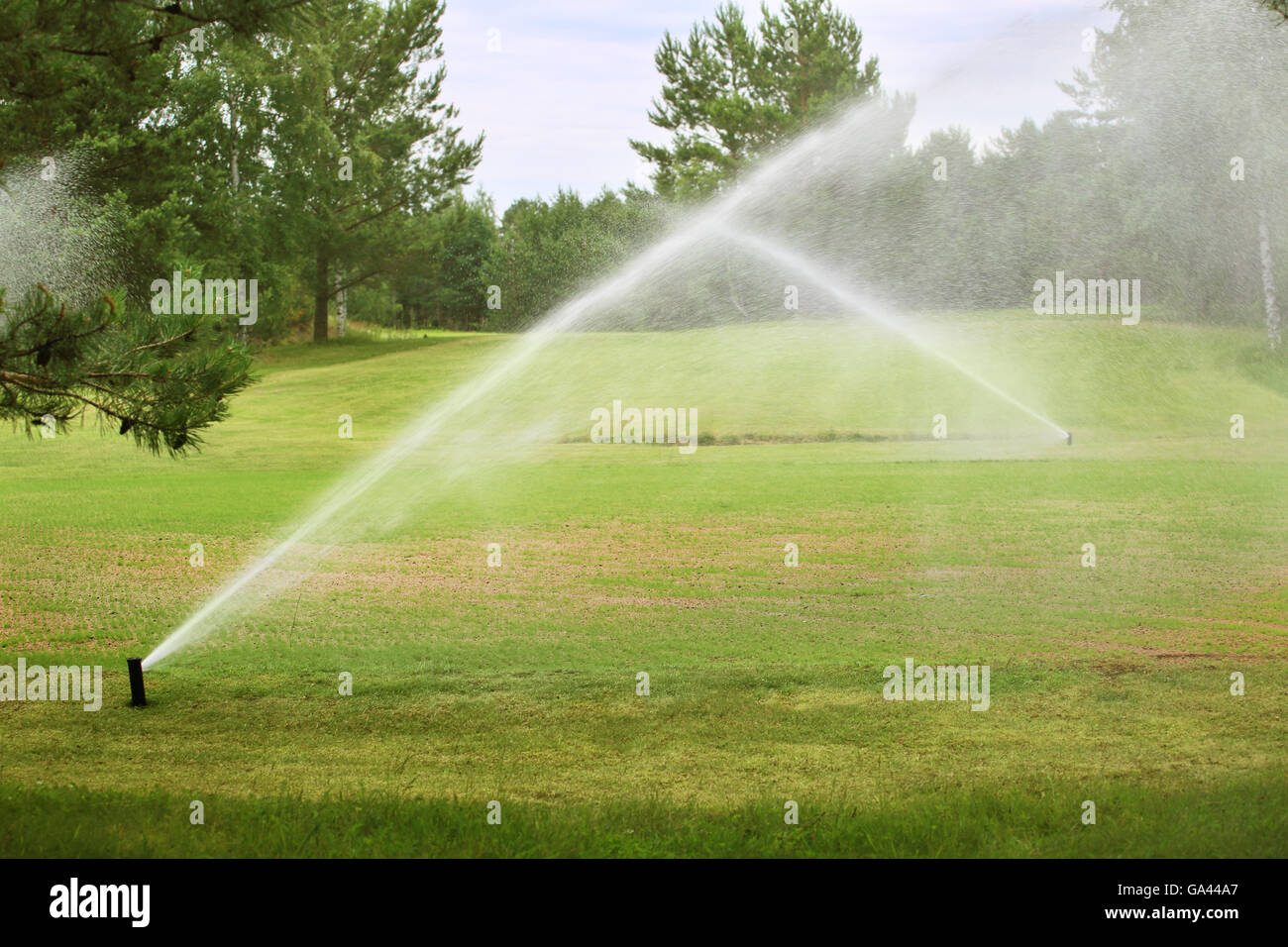 Sprinklers of automatic watering at golf course close up Stock Photo