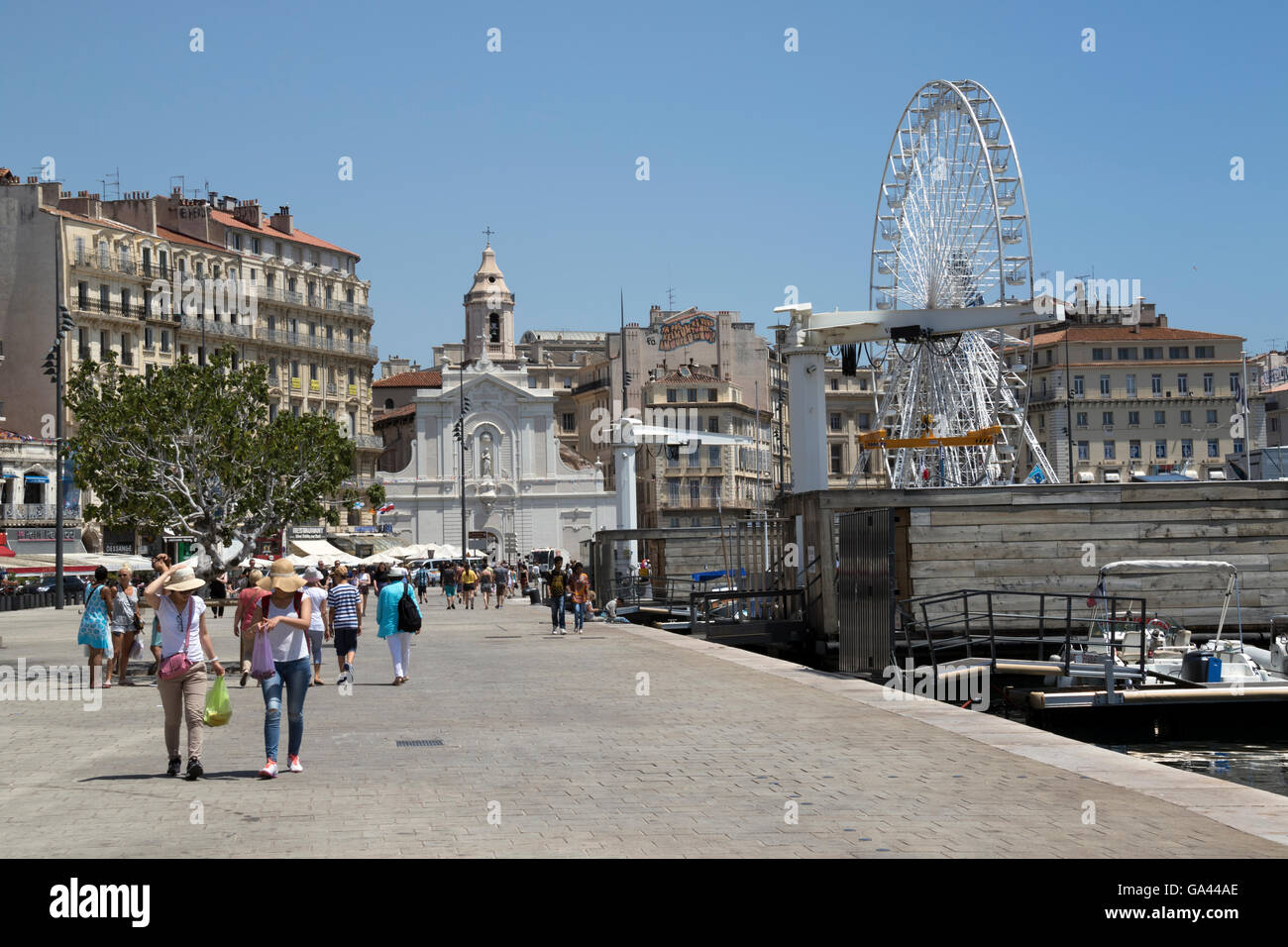 The centre of Marseilles' old port and promenade showing ferris wheel and Saint-Ferreol Cathedral. Stock Photo