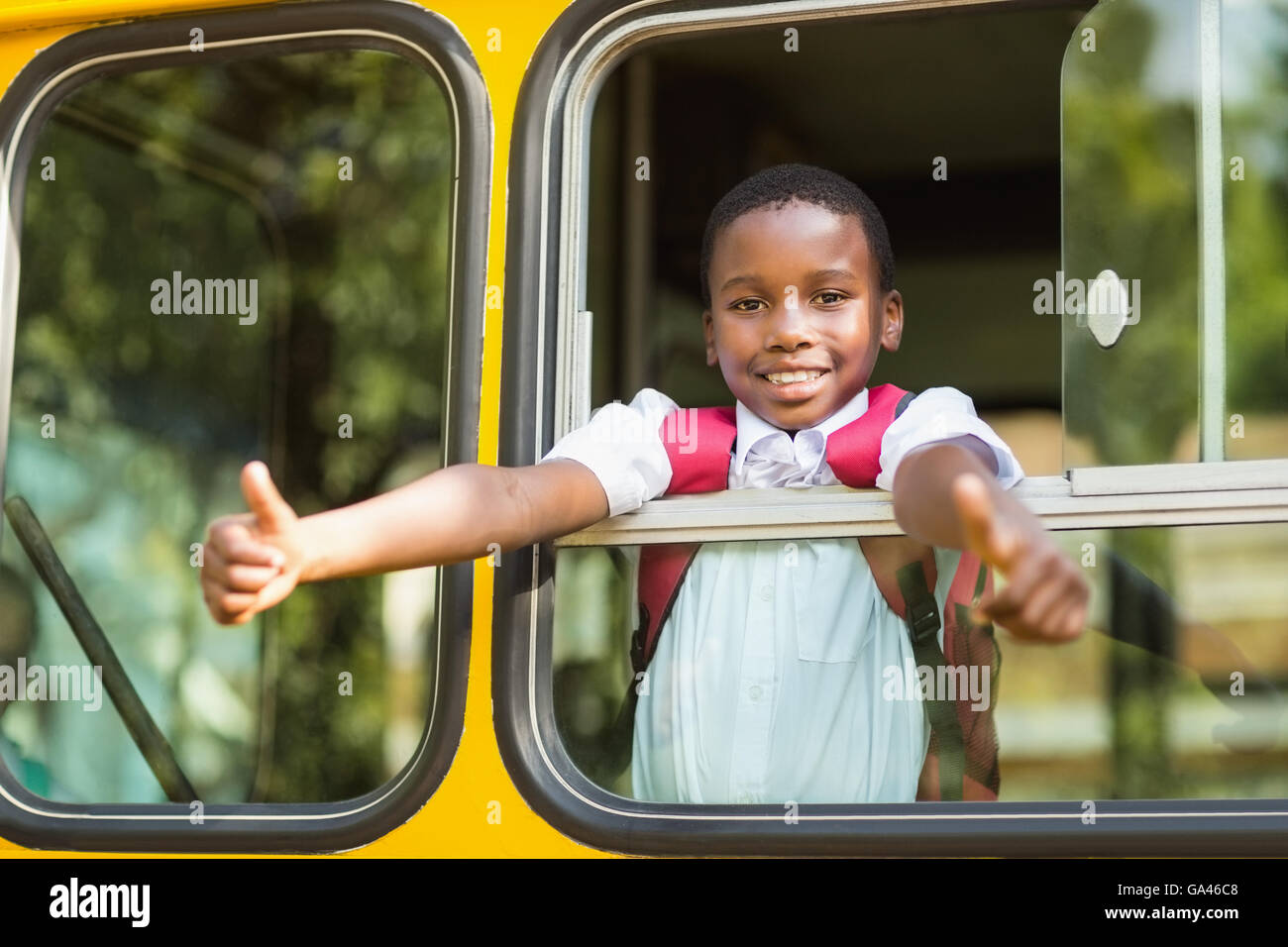 Smiling schoolboy showing thumbs up from bus Stock Photo - Alamy