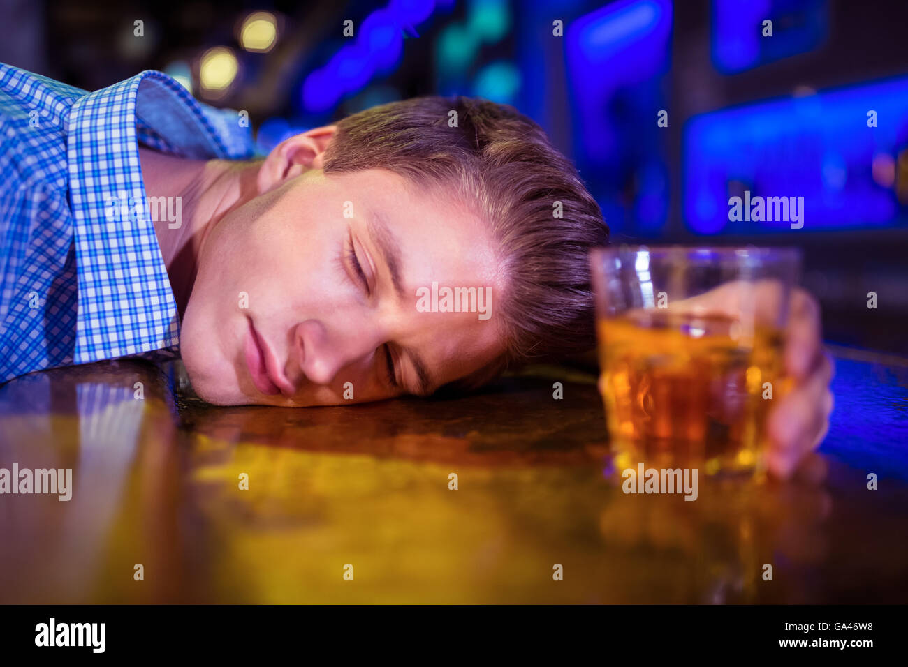 Drunk man lying on bar counter Stock Photo
