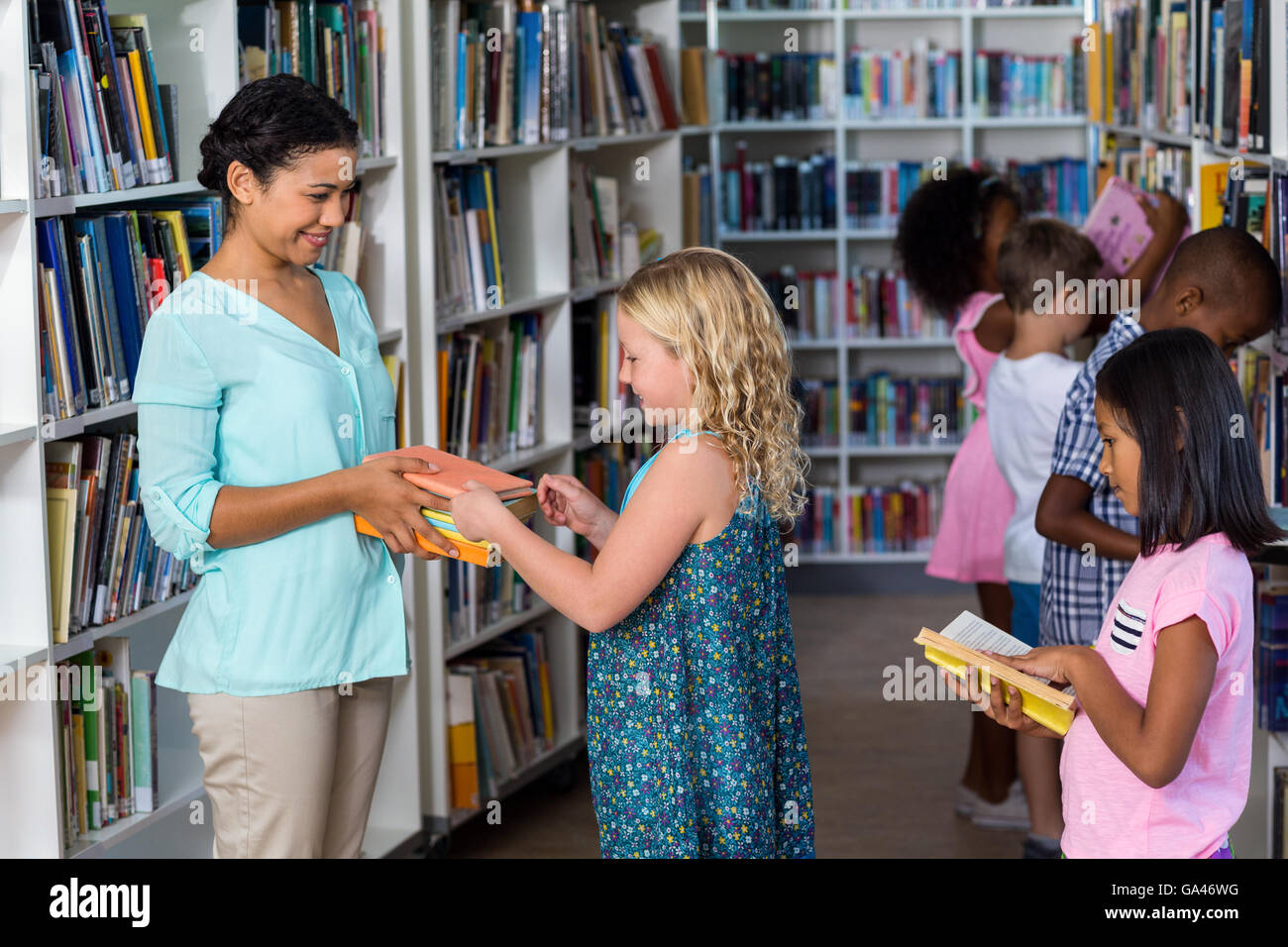 Teacher giving books to girl Stock Photo Alamy