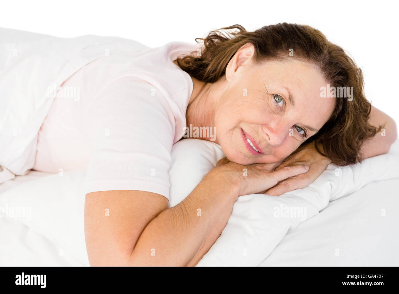 Portrait of happy mature woman lying on bed Stock Photo