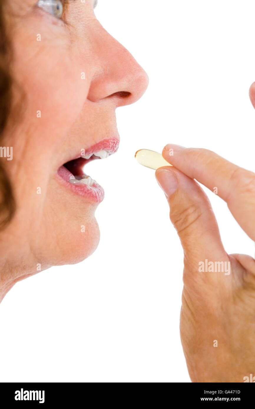 Cropped image of woman taking pill Stock Photo