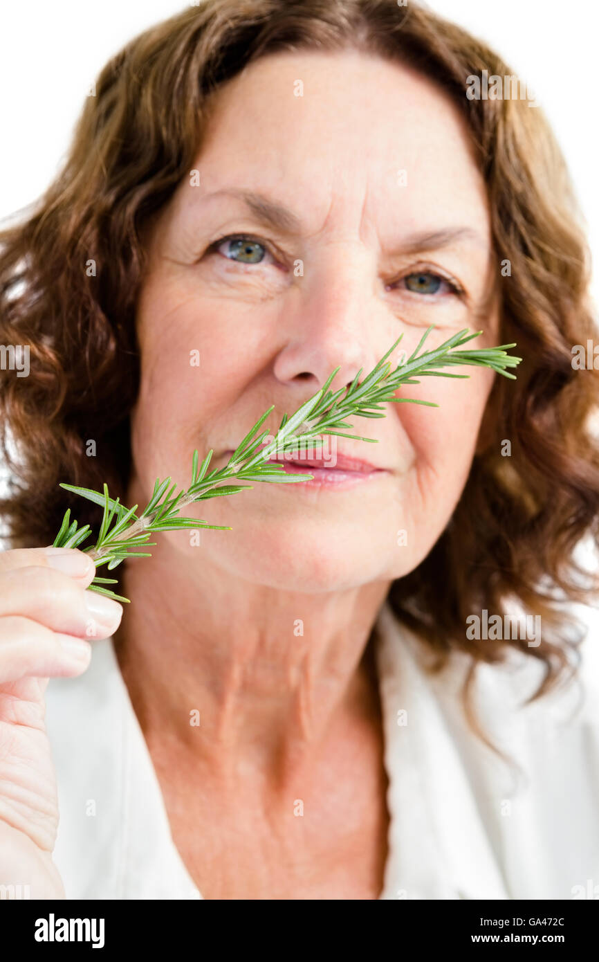 Portrait of mature woman smelling rosemary Stock Photo