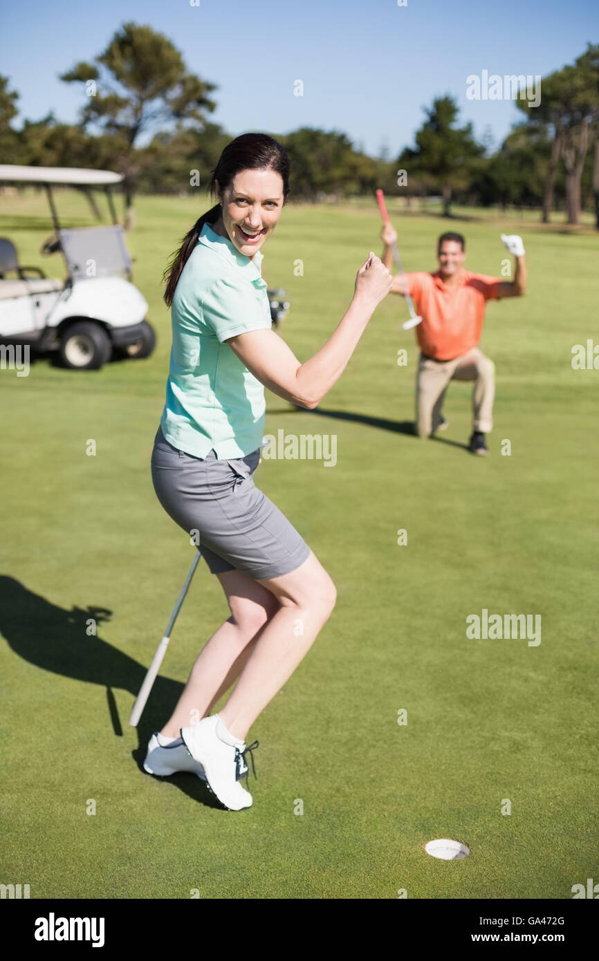 Portrait of happy golfer woman clenching fist Stock Photo