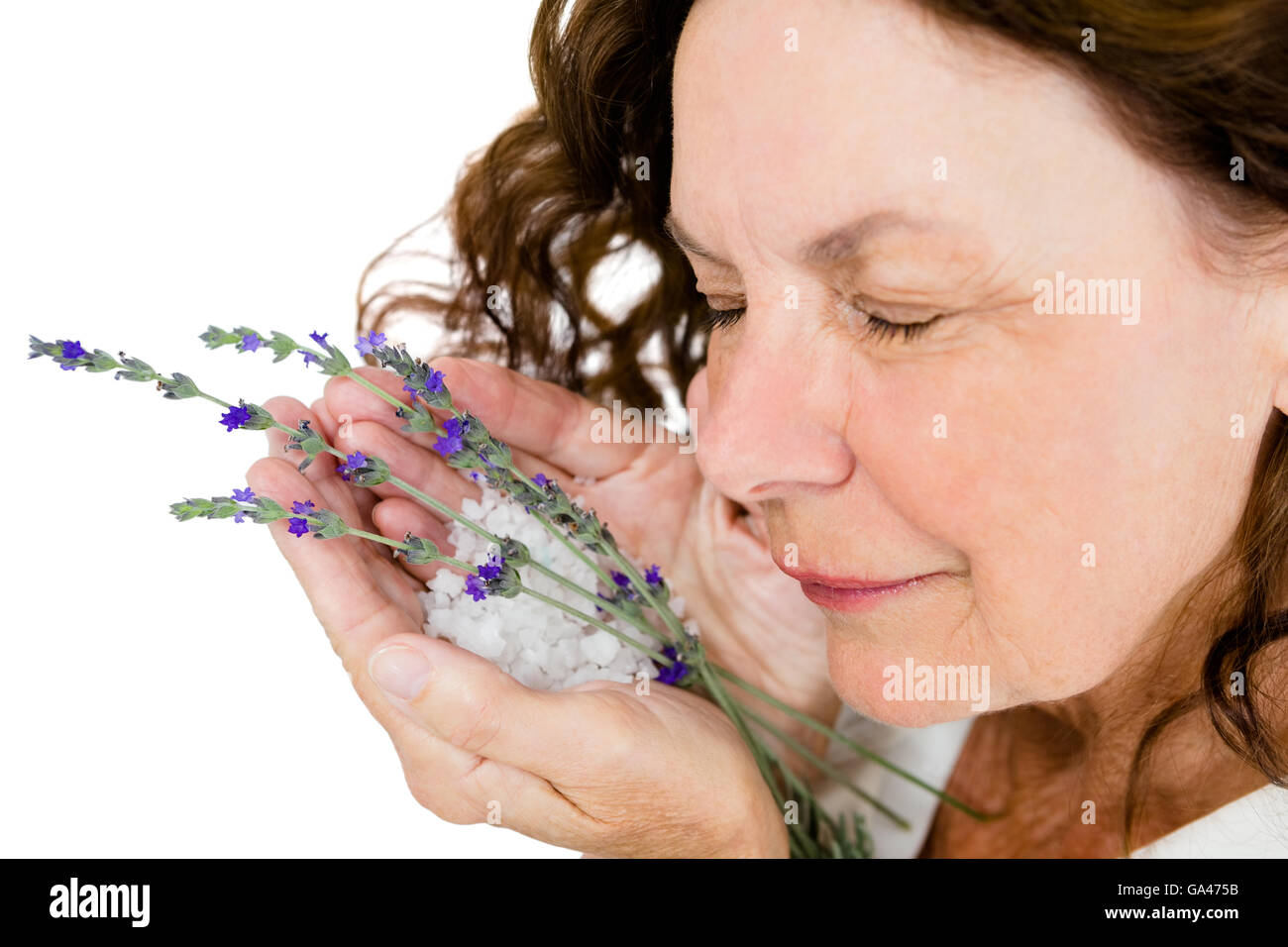 Close-up of smiling mature woman smelling flowers Stock Photo