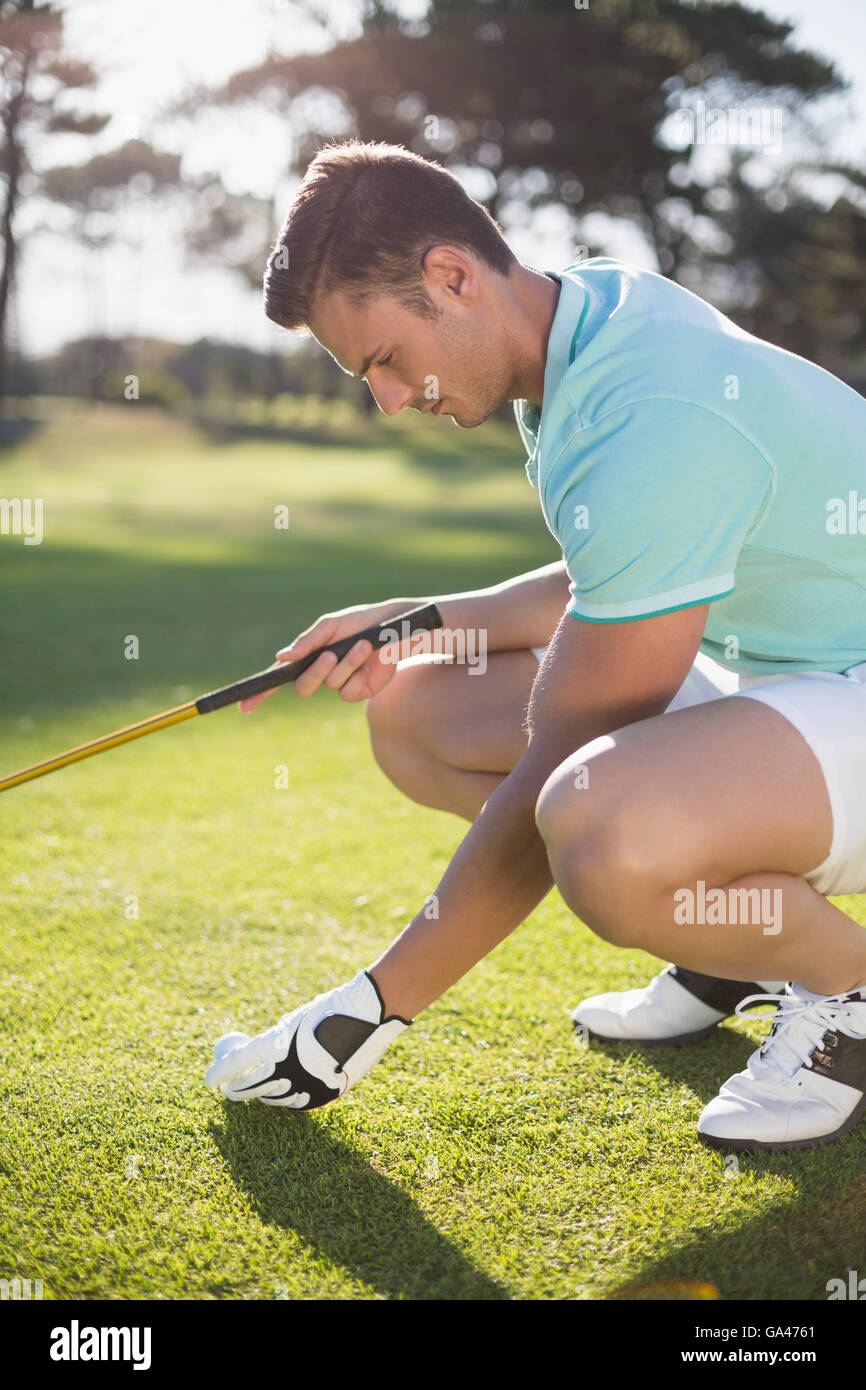 Golfer man placing golf ball on tee Stock Photo
