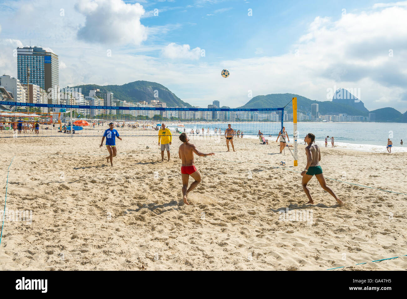 RIO DE JANEIRO - MARCH 15, 2016: Brazilian men play a game of futevôlei (footvolley, a sport combinig football and volleyball. Stock Photo