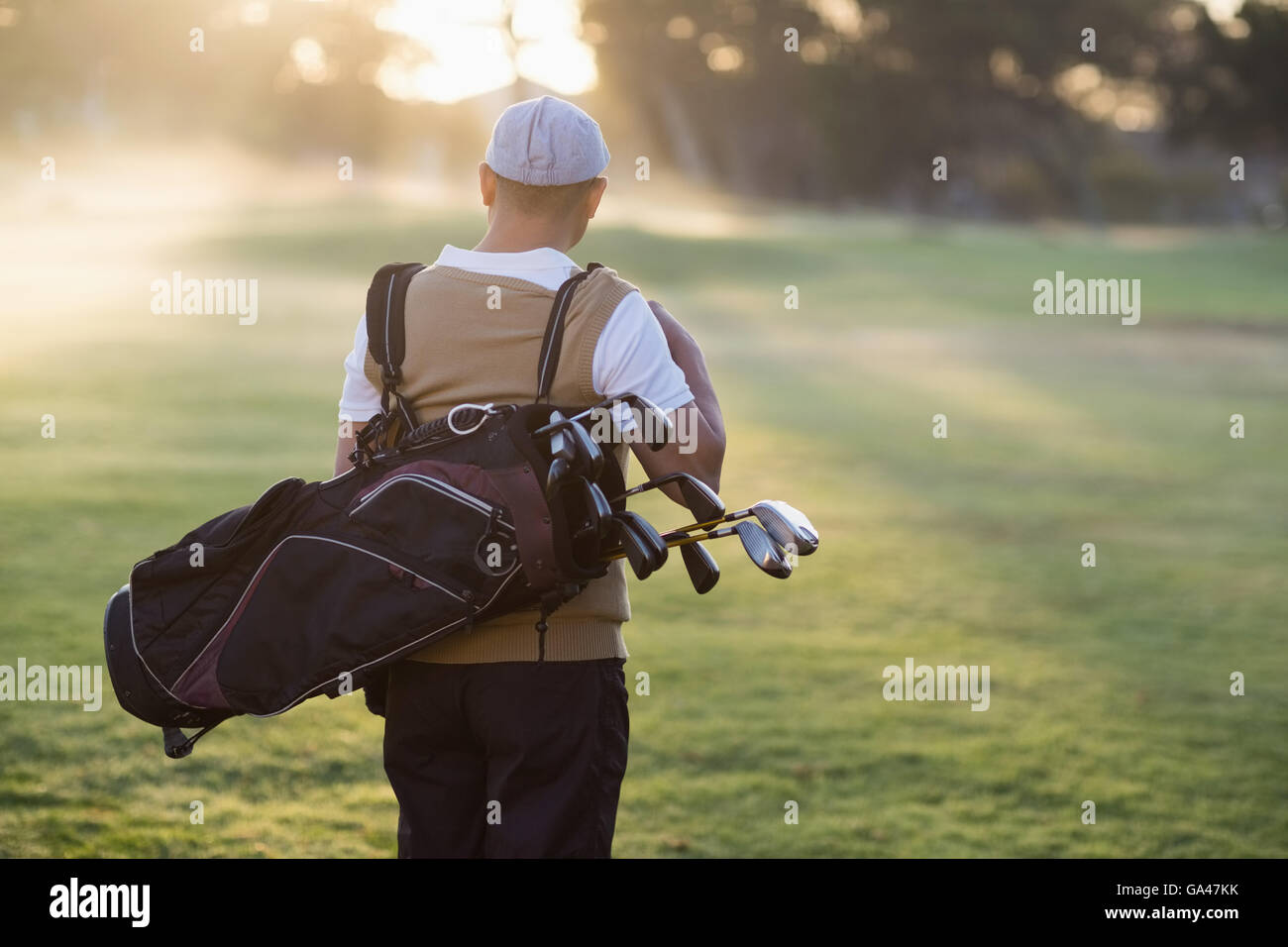Rear view of man carrying golf bag Stock Photo Alamy