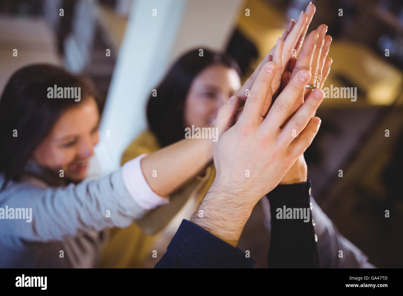 Creative business people high fiving in office Stock Photo - Alamy