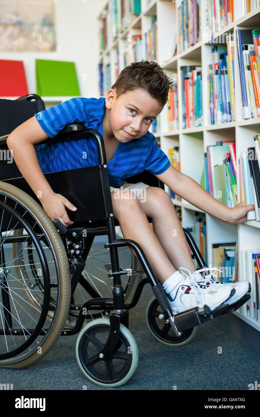 Portrait of handicapped boy searching books in library Stock Photo