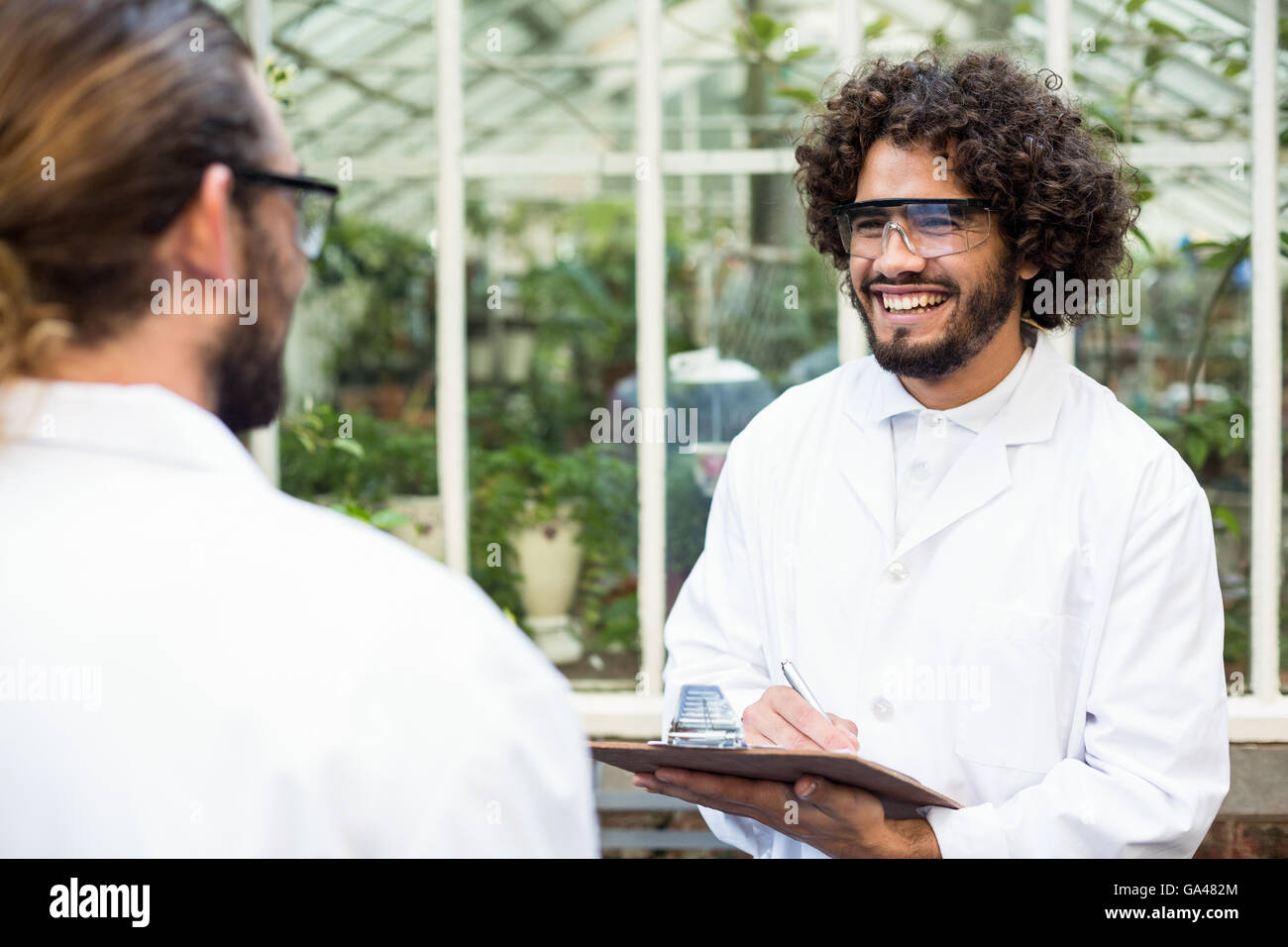 Male scientists smiling while discussing Stock Photo
