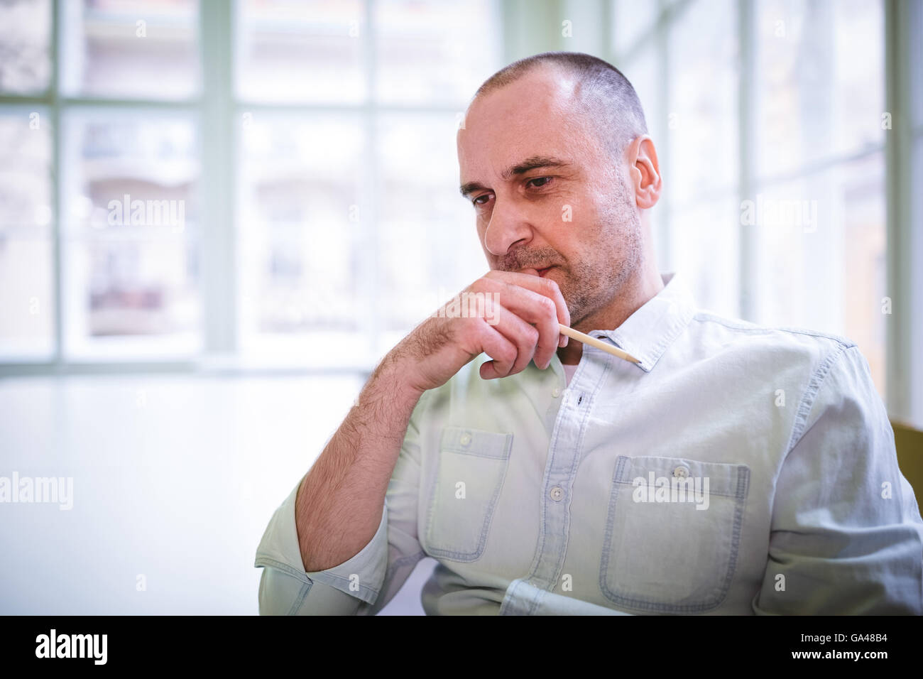 Thoughtful businessman with hand on chin Stock Photo