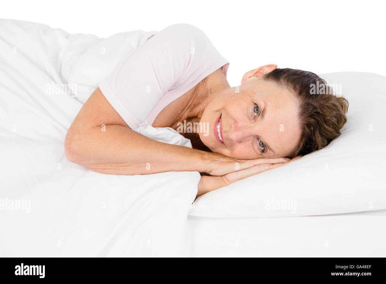 Portrait of smiling mature woman lying on bed Stock Photo