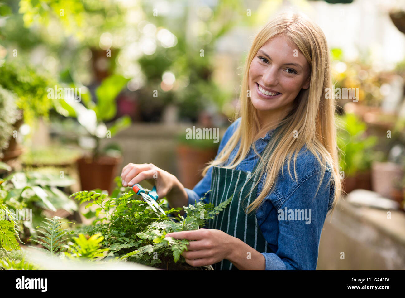 Portrait of female gardener smiling while pruning Stock Photo - Alamy