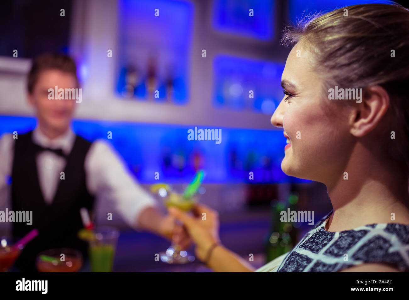 Barman serving cocktail to woman Stock Photo