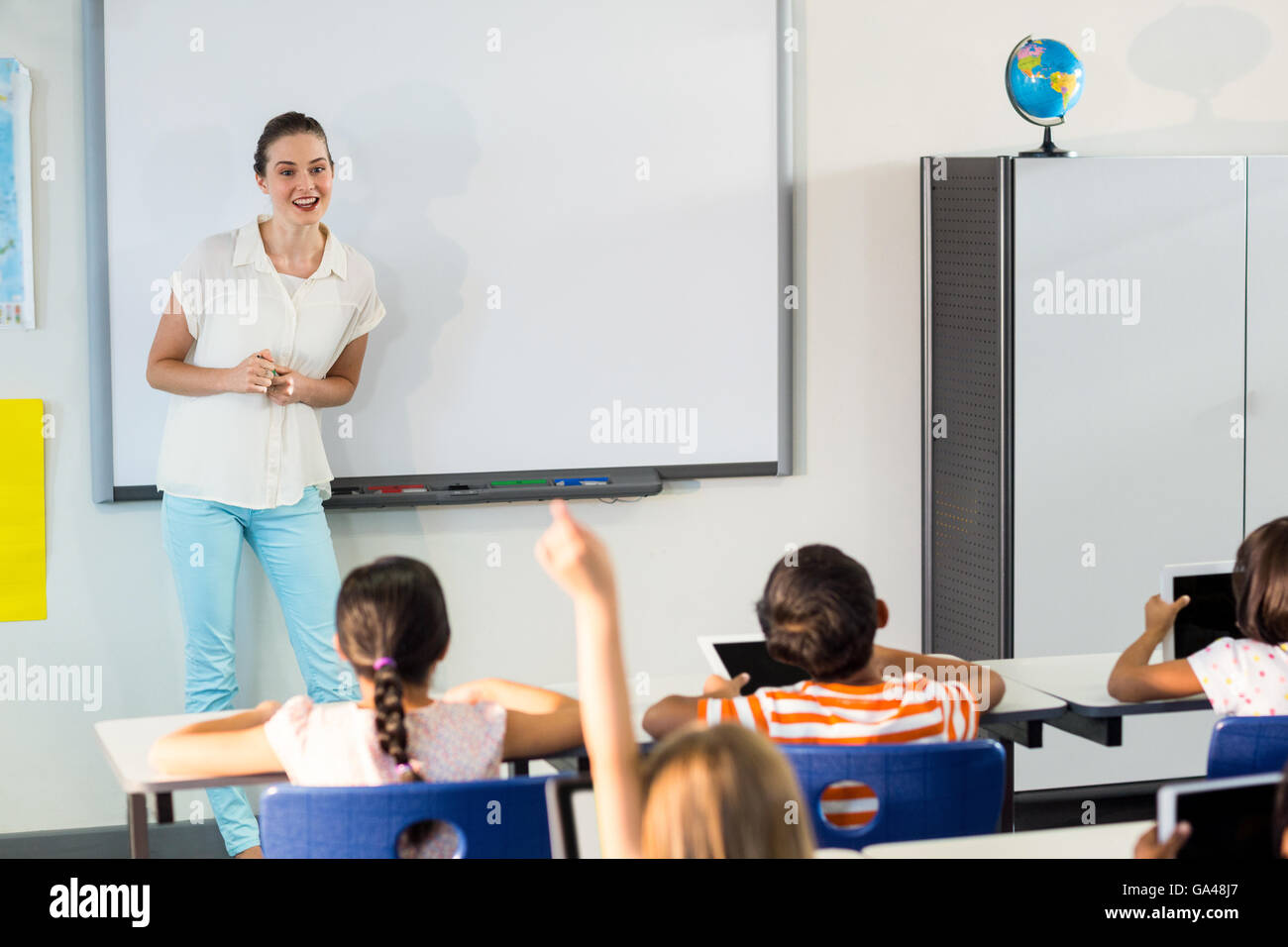 Teacher giving a lesson to pupils Stock Photo