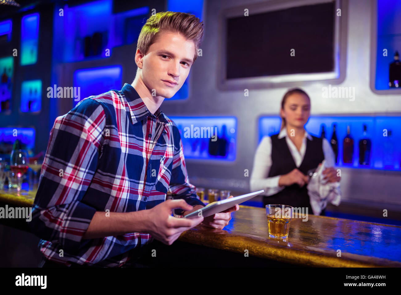 Portrait of man using digital tablet with bartender working Stock Photo