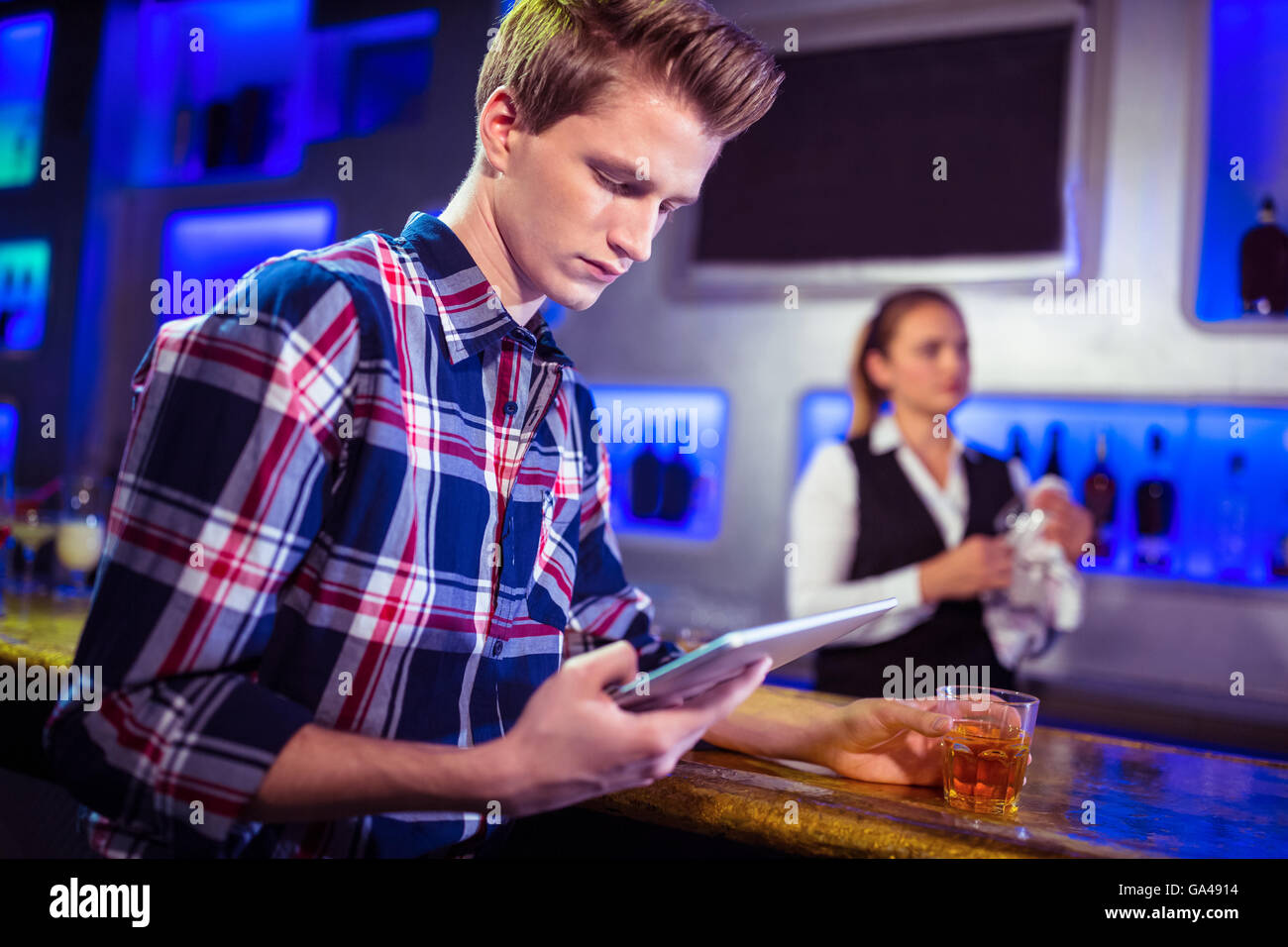 Man using digital tablet with bartender working Stock Photo