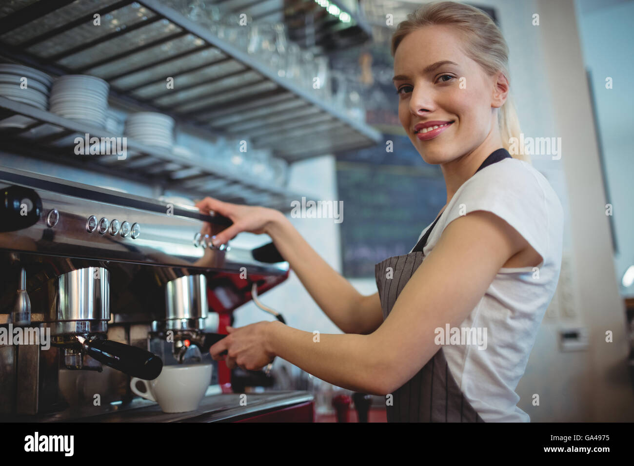 Portrait of waitress using coffee maker at cafeteria Stock Photo Alamy