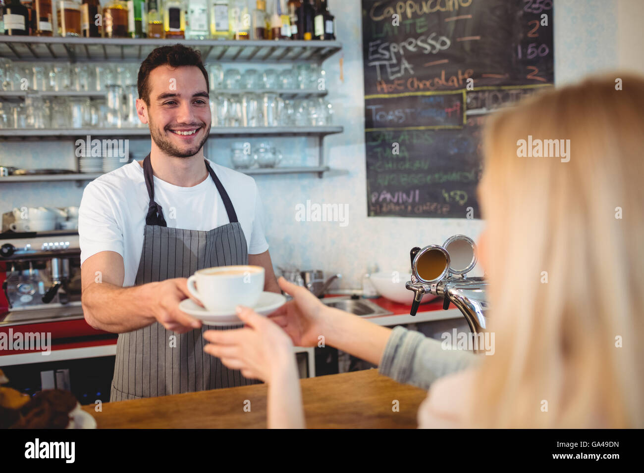 Happy barista serving coffee to woman at cafe Stock Photo Alamy