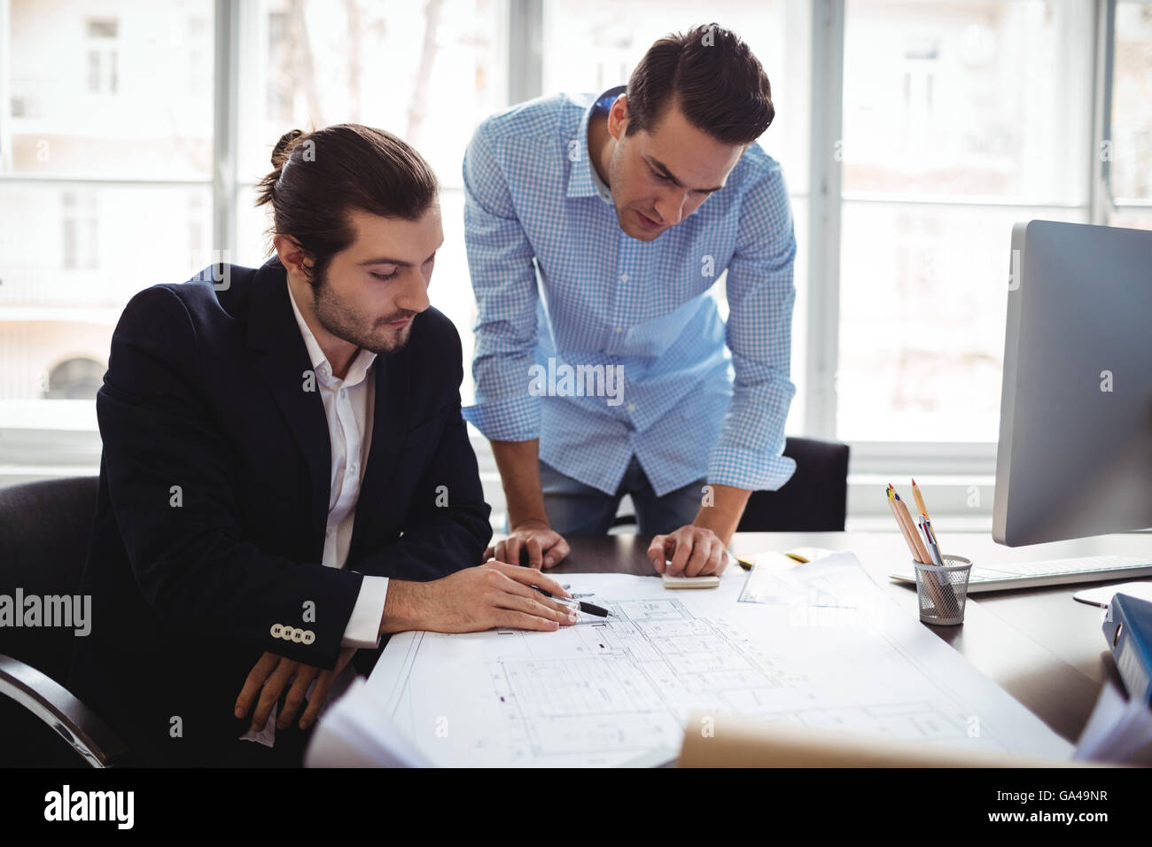Interior designer with male colleague working in office Stock Photo