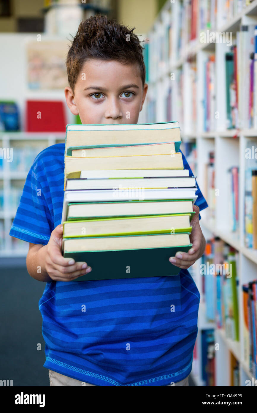 Boy holding books in school library Stock Photo