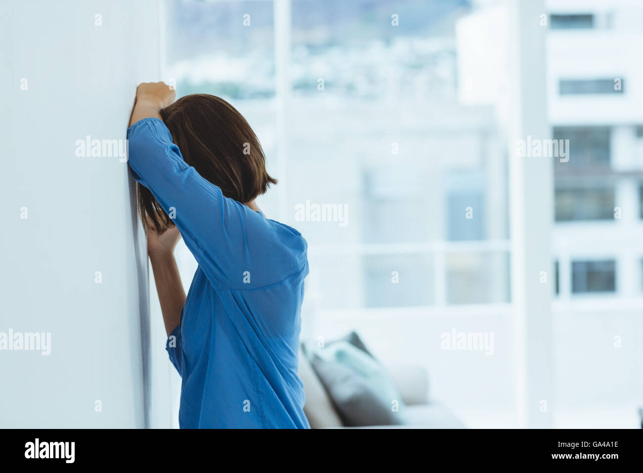 Woman standing by wall hi-res stock photography and images - Alamy