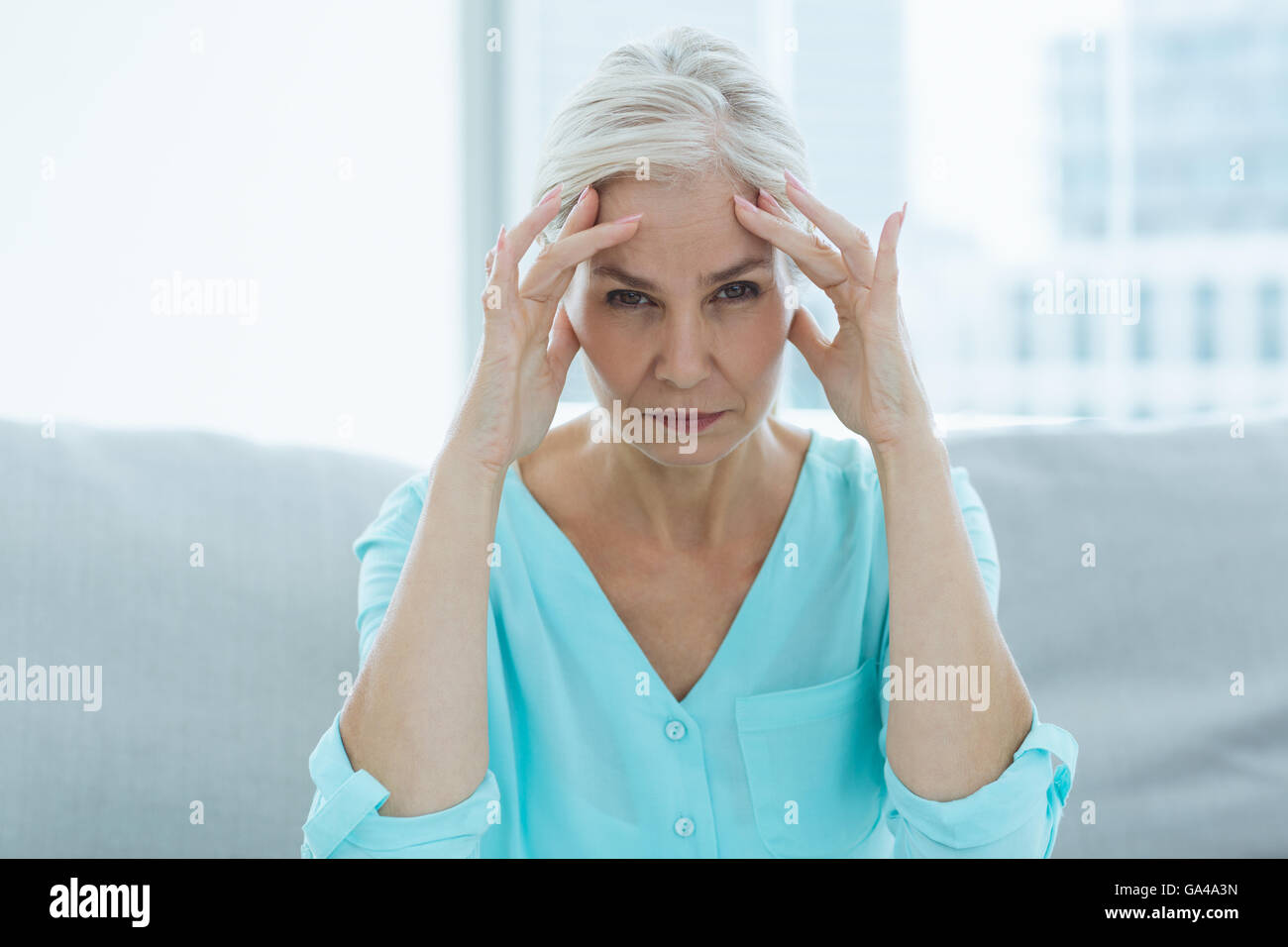 Portrait of senior woman suffering headache Stock Photo