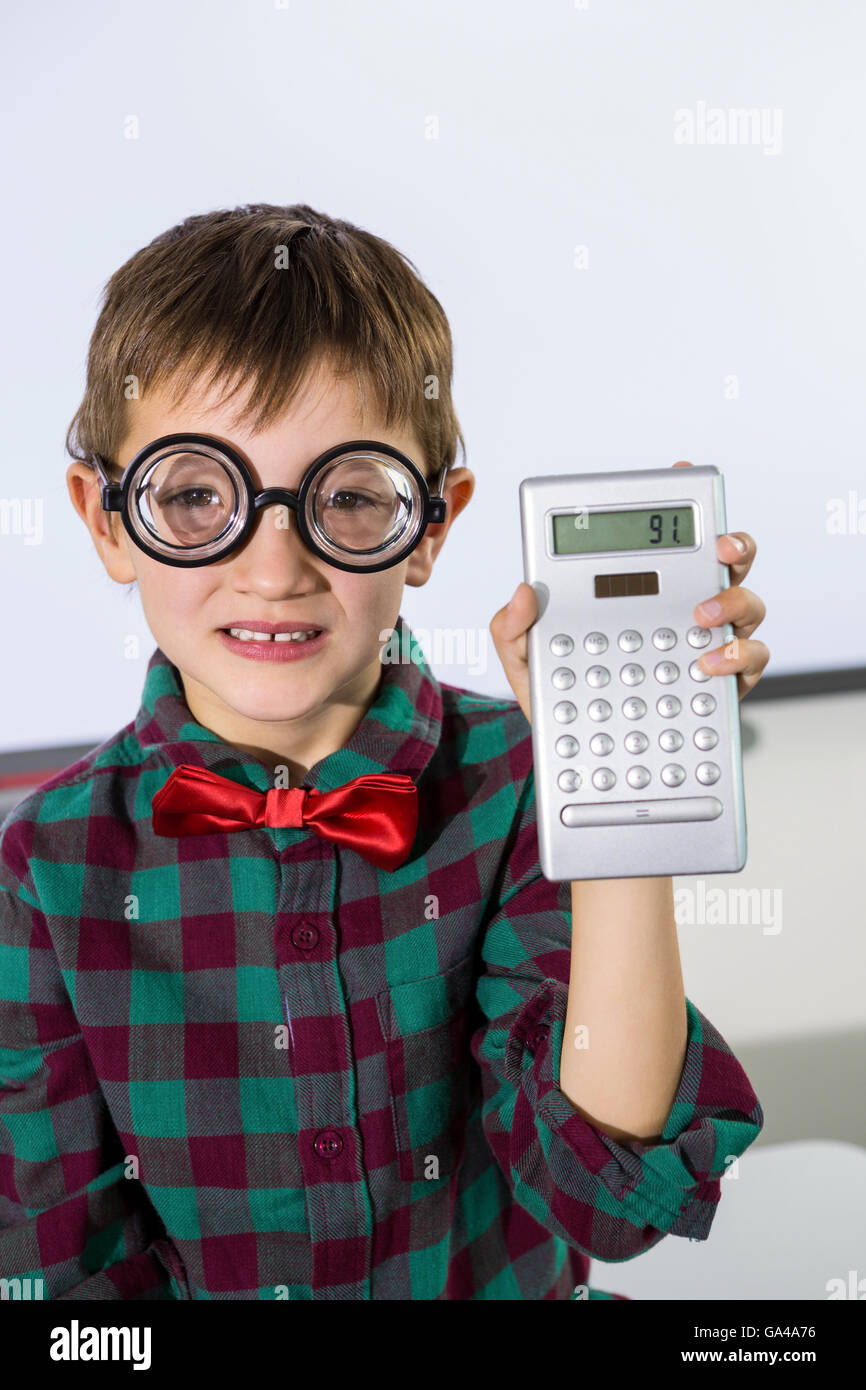 Portrait of boy holding calculator in classroom Stock Photo Alamy