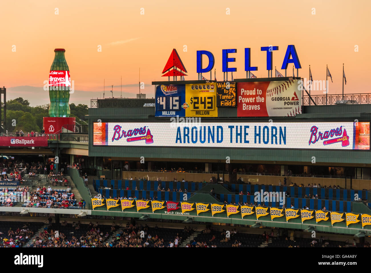 Icons of Atlanta – Coca-Cola, Delta Airlines, and the Atlanta Braves – at Turner Field against a colorful sunset sky. Stock Photo