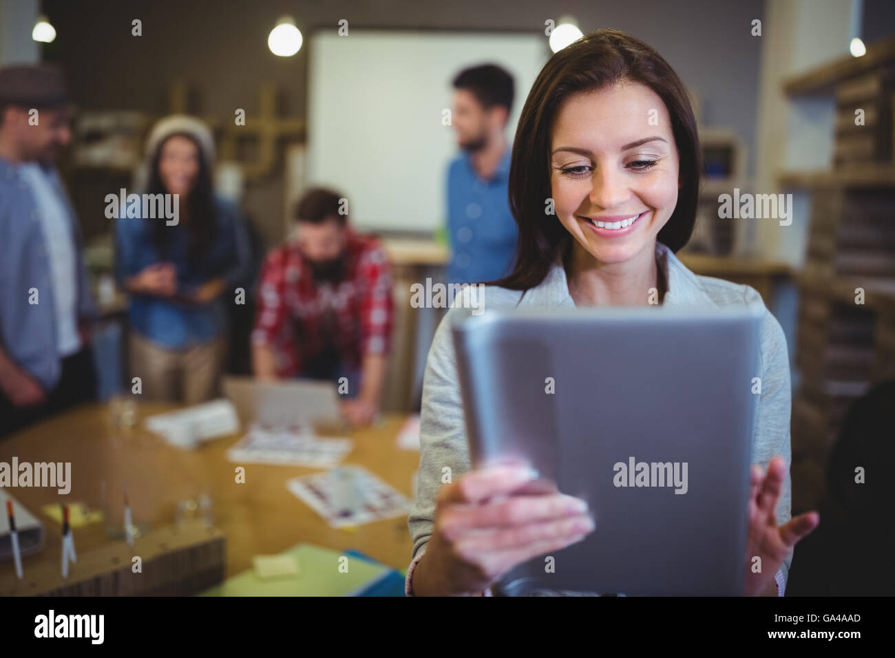 Businesswoman smiling while using digital tablet Stock Photo