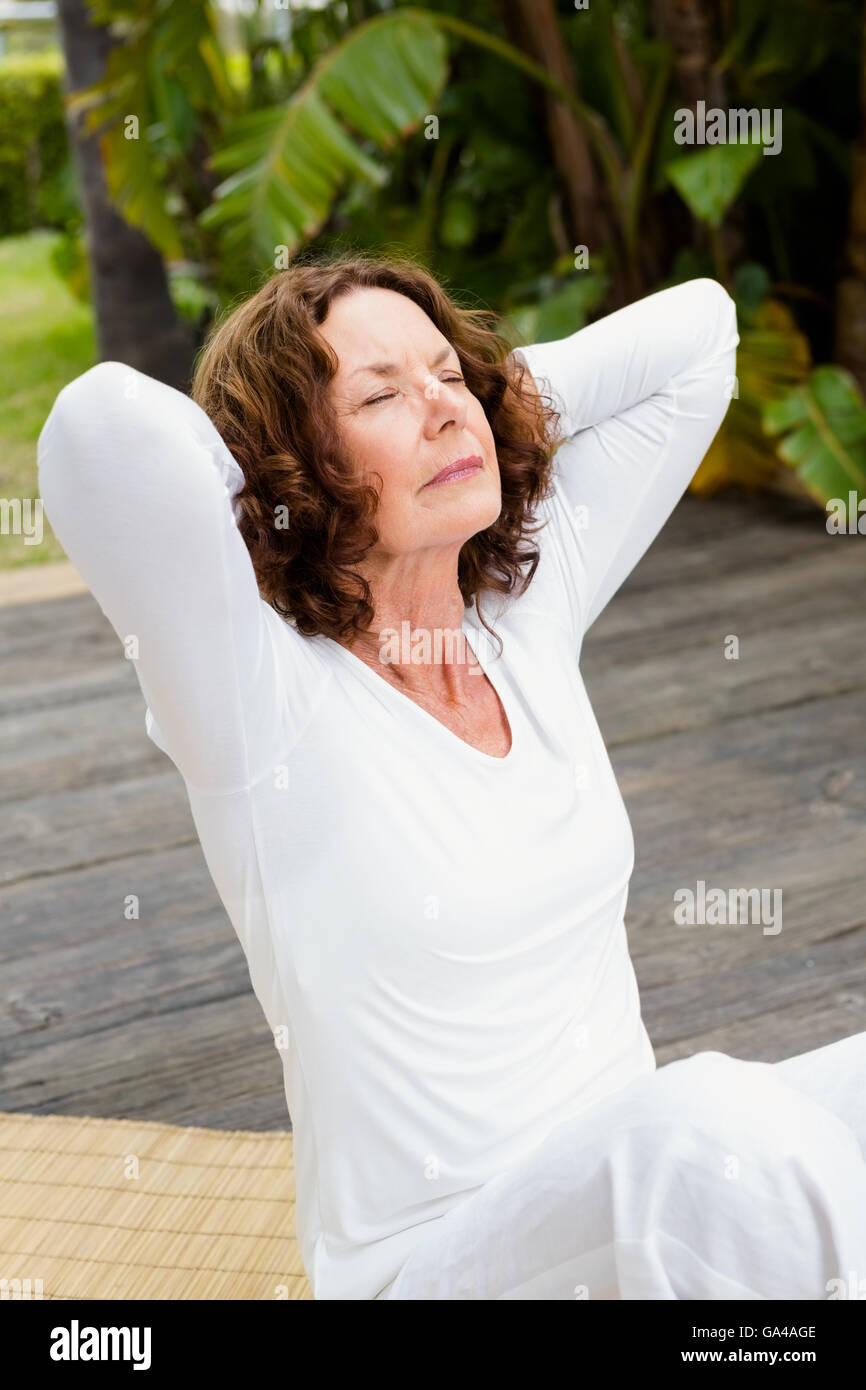 Woman with hands behind head while doing yoga Stock Photo