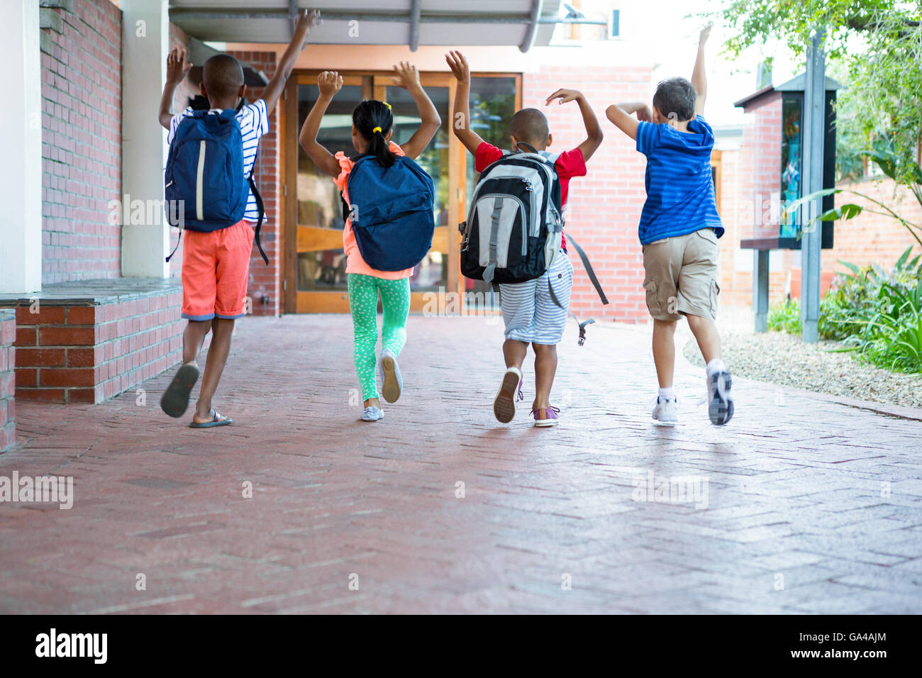 Rear view of classmates running at school corridor Stock Photo - Alamy