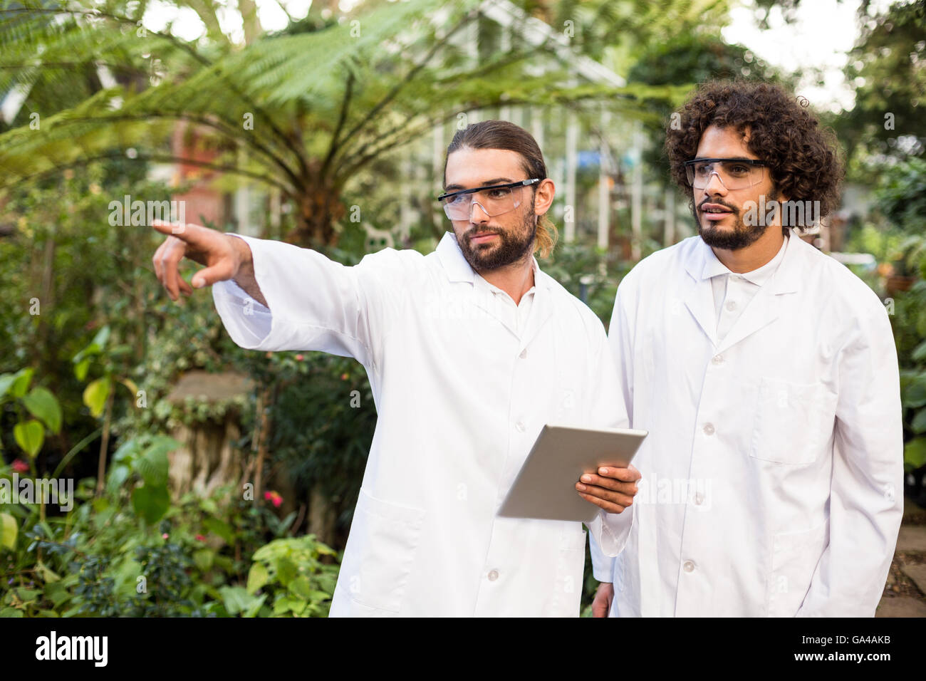 Male scientist pointing while standing by coworker Stock Photo