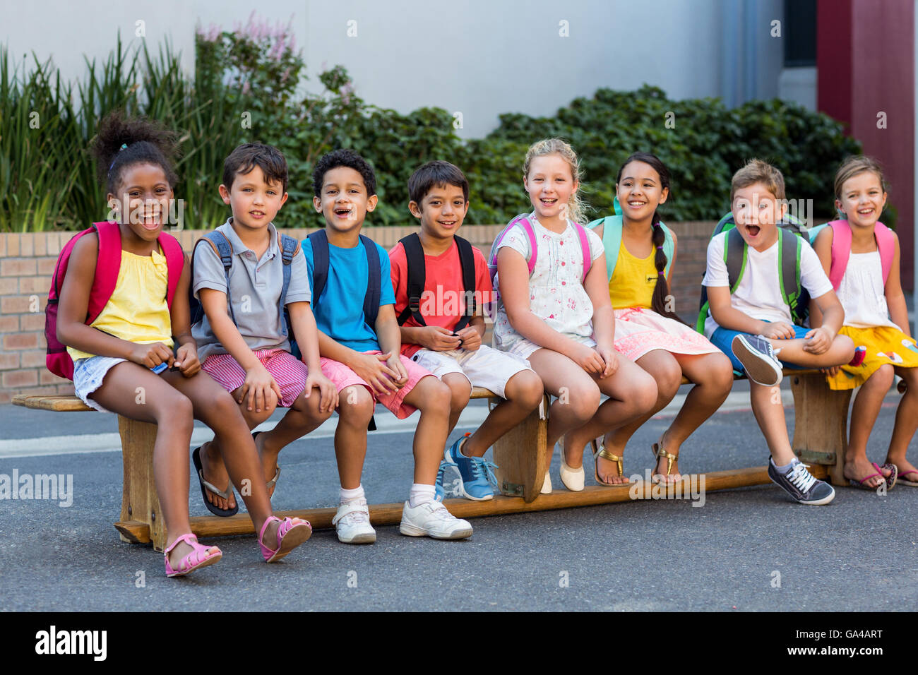 Smiling schoolchildren on seat Stock Photo