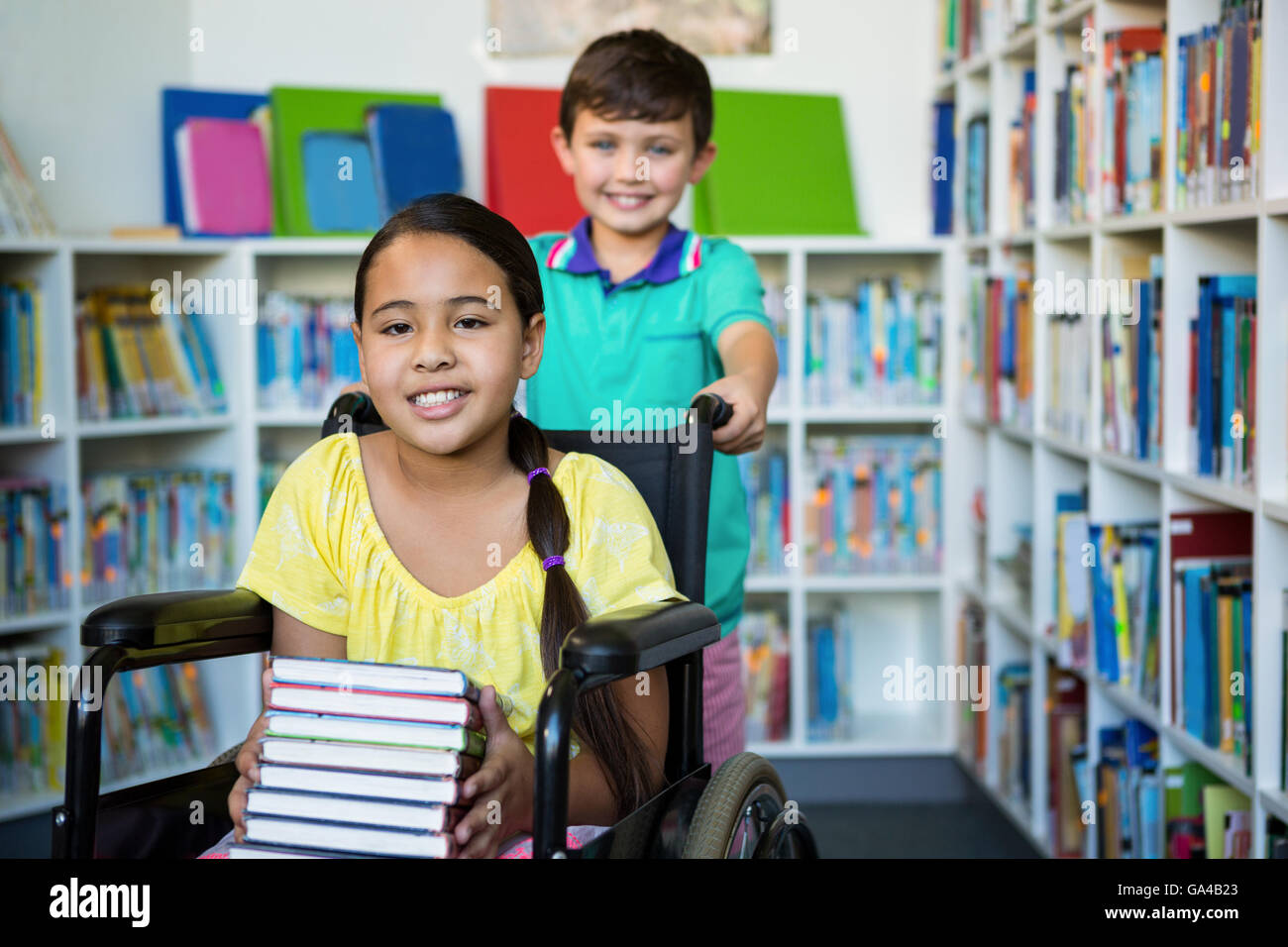 Portrait of handicapped girl with boy at library Stock Photo
