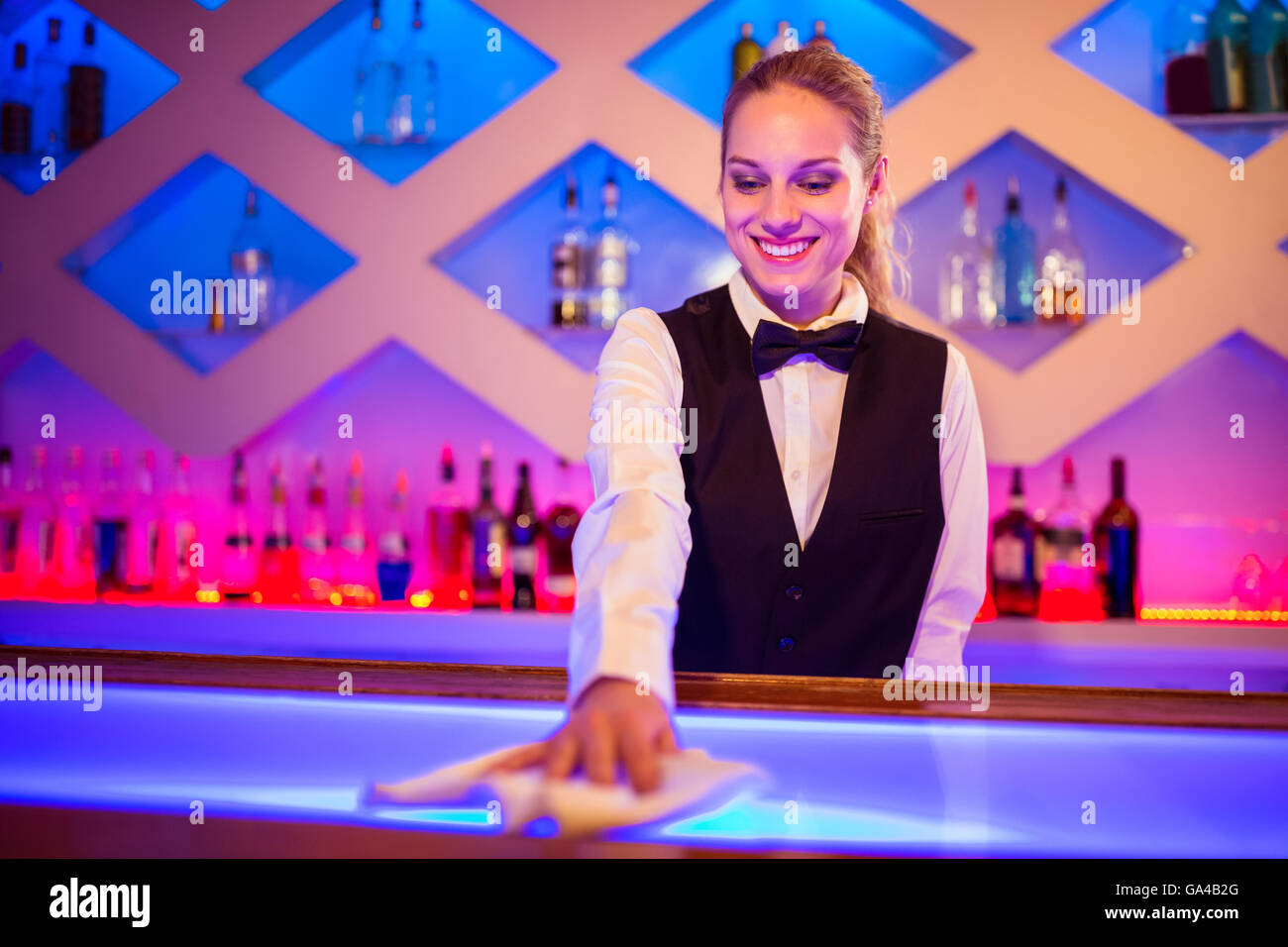 Barmaid smiling cleaning bar counter Stock Photo Alamy