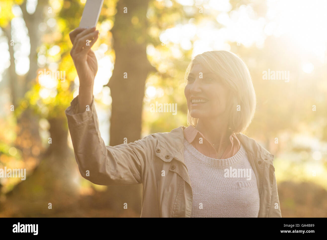 Mature woman smiling while using cellphone Stock Photo
