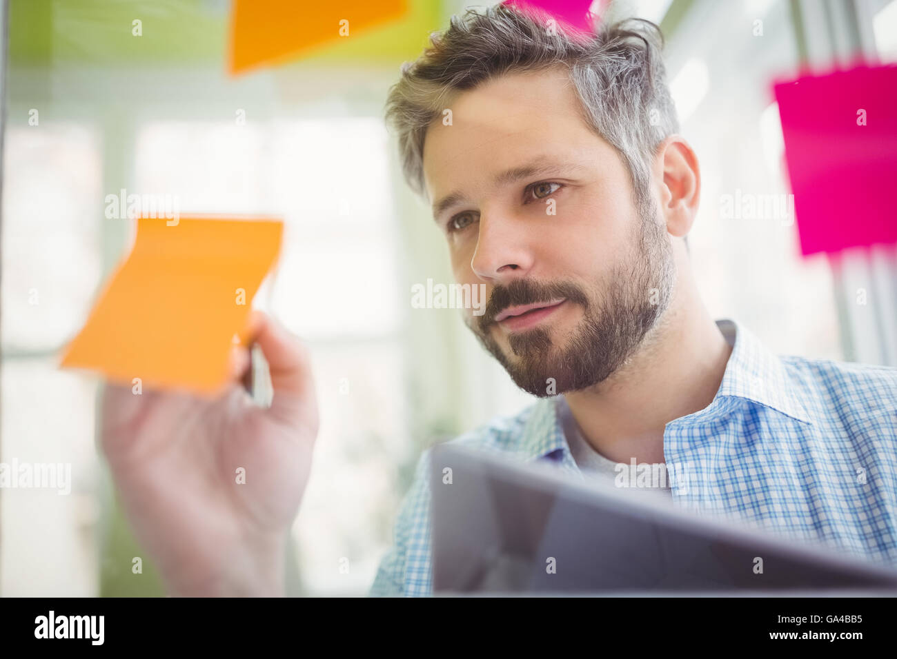 Young businessman writing on adhesive notes Stock Photo - Alamy