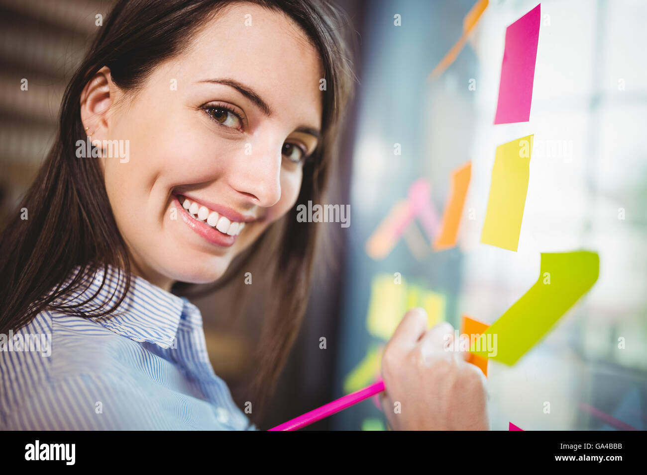 Creative businesswoman writing on sticky notes stuck to glass Stock ...
