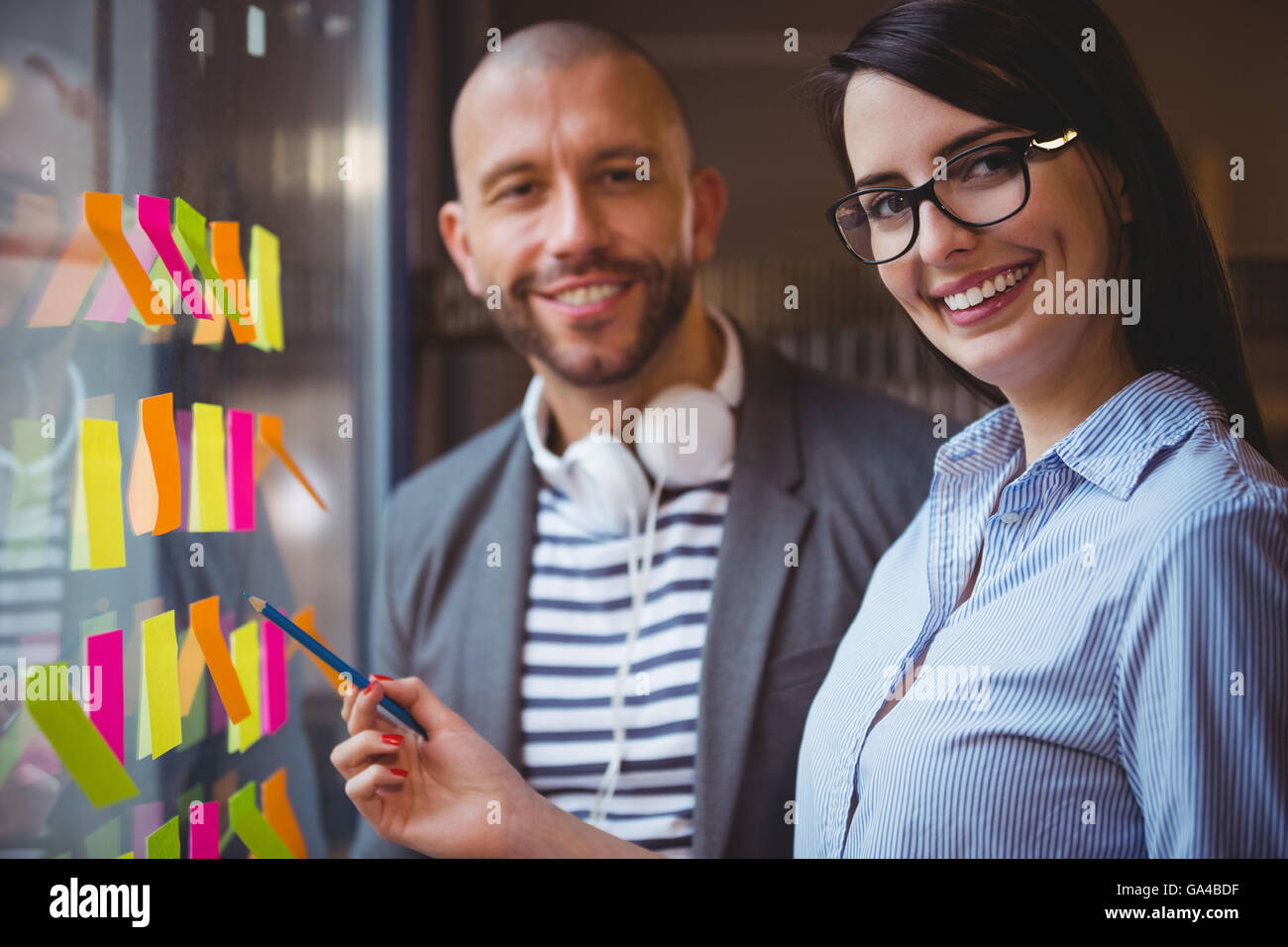 Businesswoman pointing while standing by male colleague Stock Photo