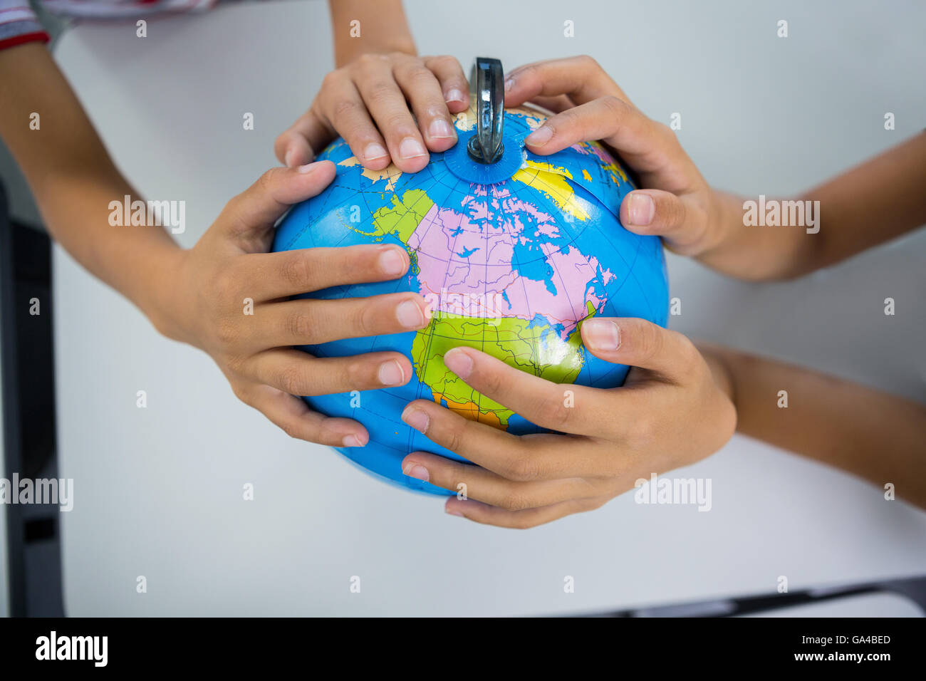 Students holding globe in classroom Stock Photo - Alamy
