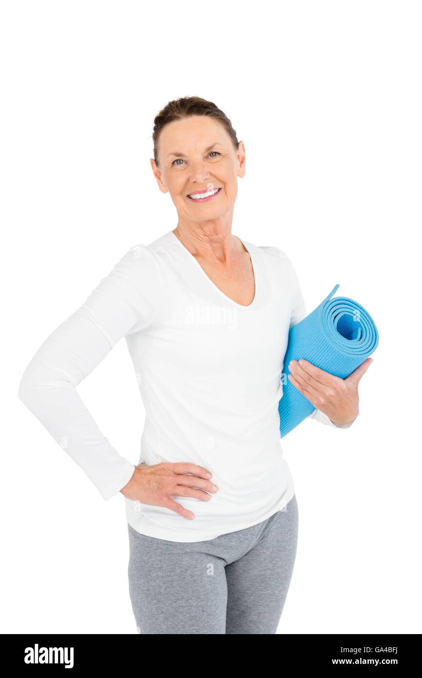 Portrait of smiling mature woman holding exercise mat Stock Photo